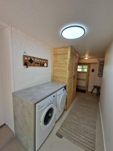 - une buanderie avec un lave-linge et un sèche-linge dans l'établissement Family-Friendly Coastal Cottage, à Henne