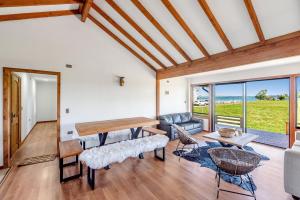 uma sala de estar com uma mesa e um sofá em Orilla de Lago con Hot Tub, parrilla y vistas em Puyehue