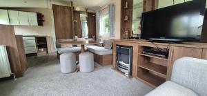 a living room with a television and a table and chairs at Excellent Static Caravan in Shanklin