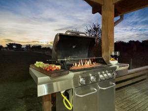 a barbecue grill with a tray of vegetables on a deck at Orilla de Lago con Hot Tub, parrilla y vistas in Puyehue