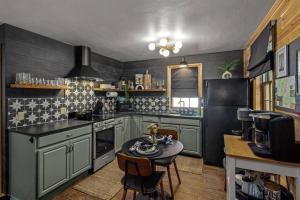 a kitchen with green cabinets and a table in it at Hot Tub, Pets OK, WiFi, Honeymoon in Eureka Springs