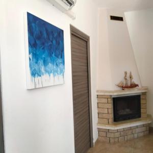 una sala de estar con chimenea y una pintura en la pared en Villa Tellina Mare Luna, en Granelli