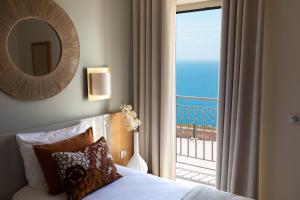 - une chambre avec un lit et une vue sur l'océan dans l'établissement Santateresa, à Bonifacio