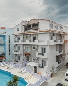 an apartment building with a swimming pool in front of it at Anna Beach Suites in Limenaria