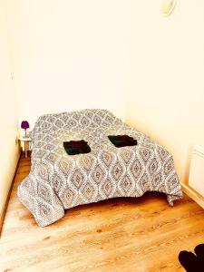 a bed with a pillow on a wooden floor at Appartement avec terrasse au coeur d'Aurillac in Aurillac
