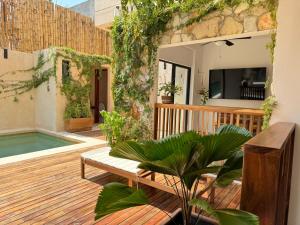 Un patio con un banco y una piscina. en Casa Ita Surf - Adults Only, en Puerto Escondido