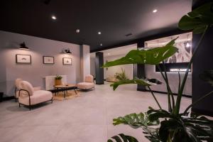 a waiting room with chairs and a table and a plant at U-Hotel Darío Lugo in Lugo