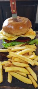 un hamburger e patatine fritte su un tavolo con un coltello di Cabinas Alemar a Paquera