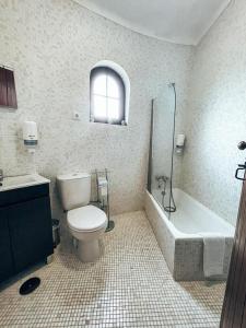 uma casa de banho com um WC, uma banheira e um lavatório. em O Moinho de Vale da Mó em Anadia