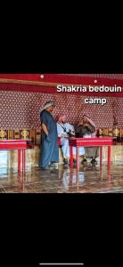 Un groupe de personnes autour d'une table rouge dans l'établissement Shakria Bedouin Life Camp, à Wadi Rum