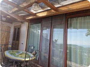 einen Balkon mit einem Tisch und Stühlen auf einer Terrasse in der Unterkunft Il Nido dei Monti in Agerola