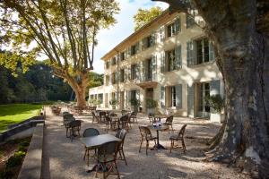 une cour avec des tables et des chaises devant un bâtiment dans l'établissement Domaine de Fontenille, à Lauris