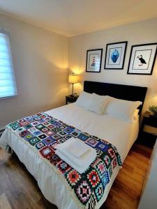 a bedroom with a bed with a colorful blanket on it at Rural Town Oasis in Bonavista +8 photos