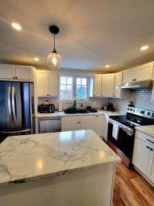 a kitchen with white cabinets and a black refrigerator at Rural Town Oasis in Bonavista +8 photos