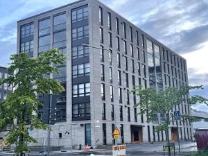 a large gray building with windows on a street at Hotellitason kodikas 90 m2 huoneisto in Tampere