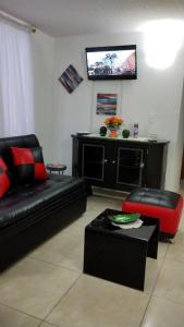 sala de estar con sofá y TV en la pared en Alojamiento en Cúcuta al lado del Centro Comercial Jardín Plaza, en Cúcuta