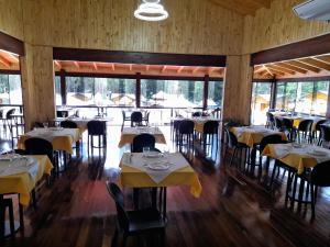 a dining room with tables and chairs and windows at Cabañas San Valentín in Eldorado