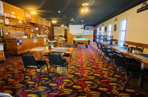 a restaurant with tables and chairs on a colorful carpet at Theodore Motor Hotel in Theodore
