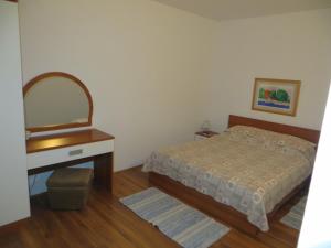 a bedroom with a bed and a dresser and a mirror at Apartments Makjanić in Jelsa