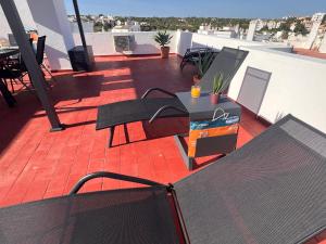 a balcony with a table and chairs on a roof at Green Apartment in Tavira Garden in Tavira