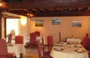 un restaurante con mesas blancas y sillas rojas en Moulin de Bourgchateau, en Louhans