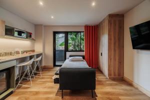 a hospital room with a bed and a tv at The Somos Central Hotel Poblado in Medellín