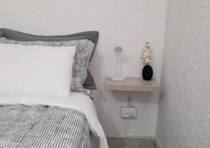 a bedroom with a bed and a side table with a lamp at Habitación 2 Santa Catalina in Floridablanca