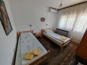 een kleine slaapkamer met 2 bedden en een raam bij Apartments Domaćinstvo Nikolić in Valjevo
