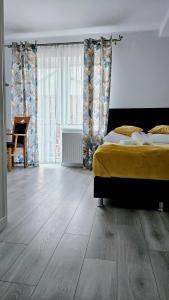 1 dormitorio con 1 cama y suelo de madera en Solar Bed & Breakfast, en Karwia