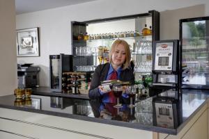 a woman behind the counter of a bar at Best Western London Highbury in London