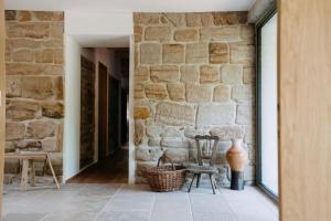 a room with a stone wall and a chair and a table at Chalupa Čížovka in Kněžmost