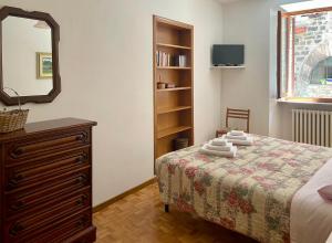 a bedroom with a bed with a dresser and a mirror at Casa Gentile in Assisi