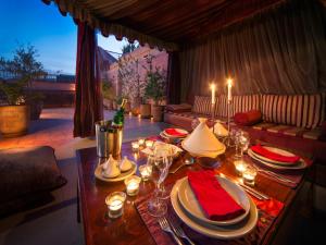 einen Esstisch mit Tellern und Weingläsern darauf in der Unterkunft Riad Darhani in Marrakesch