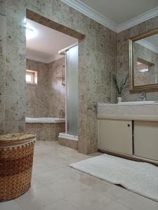 La salle de bains est pourvue d'une baignoire, d'un lavabo et d'un miroir. dans l'établissement Fátima-Ourém - Quinta da Luz - breakfast included, à Ourém