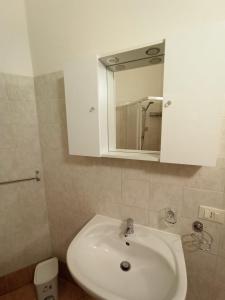 a bathroom with a white sink and a mirror at Casa del Papavero in Piombino