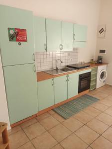 a kitchen with white cabinets and a sink and a dishwasher at Casa del Papavero in Piombino