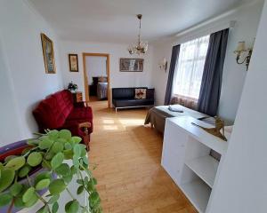 a living room with a red chair and a couch at Spacious Apartment -Top Location in Akureyri +7 photos