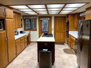 a kitchen with wooden cabinets and a stainless steel refrigerator at Wawona Home in Wawona