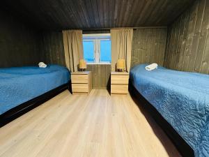 1 dormitorio con 2 camas y ventana en Bugøynes, en Bugøynes