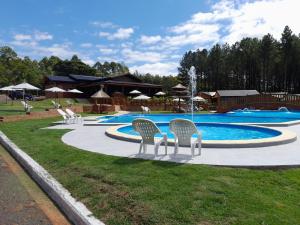 a swimming pool with chairs and a fountain at Cabañas San Valentín in Eldorado