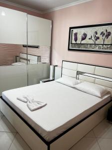 a bedroom with a large white bed with towels on it at AMY'S LUXURY APPARTMENT in Shkodër +68 photos
