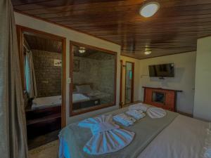 a bedroom with a bed with towels on it at Pousada Recanto do Escorrega in Visconde De Maua