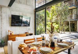 ein Esszimmer mit einem Tisch und einem großen Fenster in der Unterkunft Amazing 1BR Swim Up Cenote Gym in Tulum