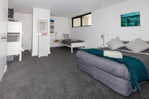 a bedroom with a large bed and a desk at Eleven_at_Mauao in Mount Maunganui