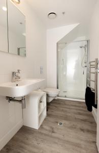 a white bathroom with a sink and a toilet at Eleven_at_Mauao in Mount Maunganui