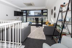 Una sala de estar con un sofá y un televisor. en Eleven_at_Mauao, en Mount Maunganui