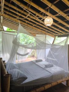 łóżko w pokoju z siecią w obiekcie Finca La Selvita w mieście Buritaca