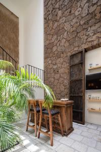 a wooden table and chairs next to a stone wall at HOLT Parque Juarez Privada Stunning 5BR Villa in San Miguel de Allende