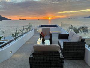 a patio with a hot tub on the beach at sunset at Hotel Star in Manzanillo