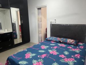 1 cama con edredón azul y cabecero negro en Island Guesthouse - entire one bedroom unit with kitchen & a bathroom centrally located in Votualevu, en Nadi